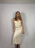 Woman wearing a floral skirt set against a plain white background