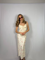 Woman wearing a floral skirt set against a plain background