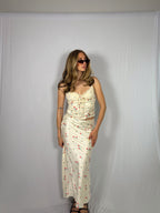 Woman wearing a floral skirt set against a plain background
