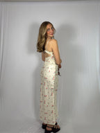 Woman wearing a floral skirt set against a plain white background faced backwards