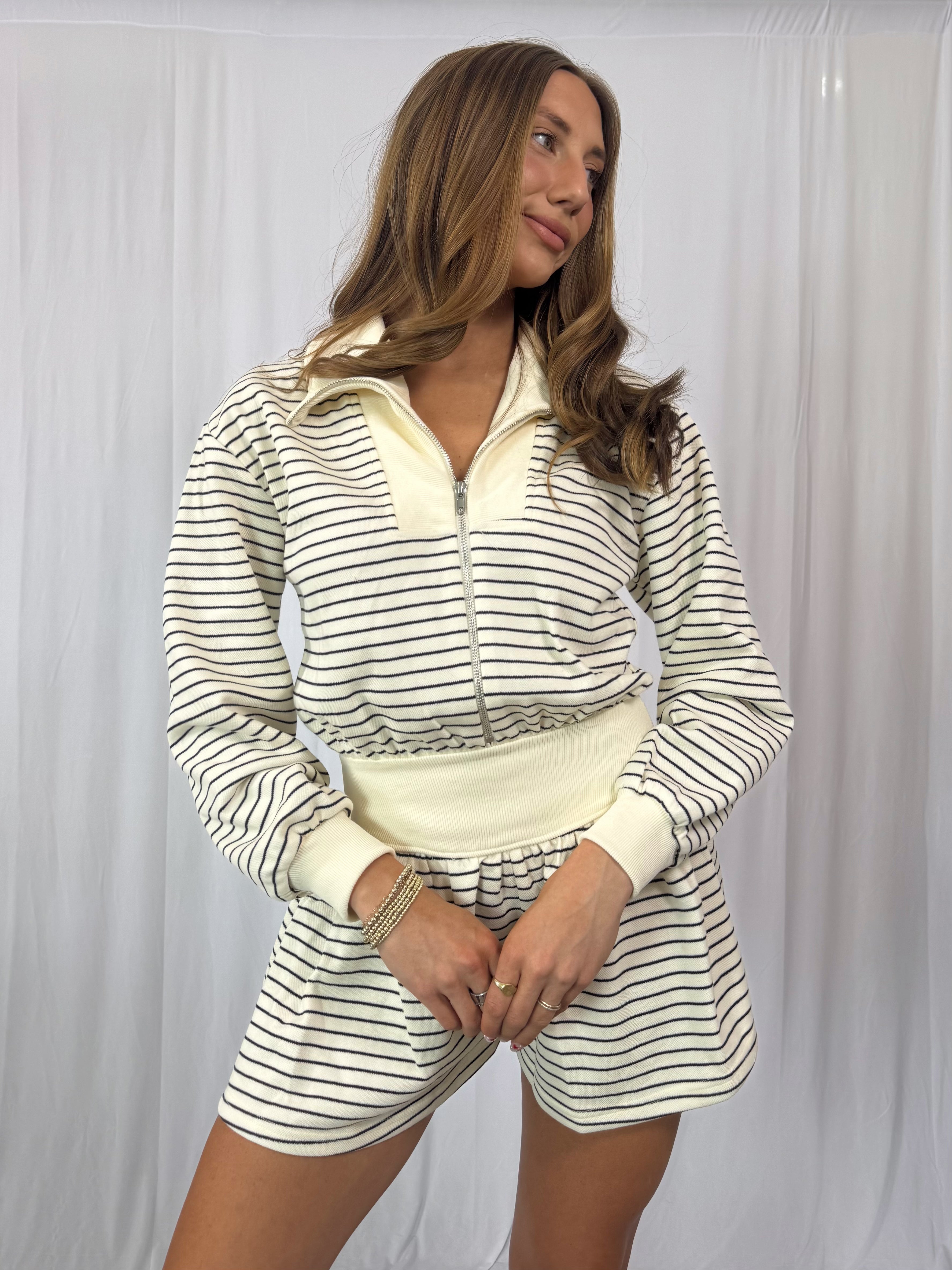 Woman wearing a striped romper with a white background