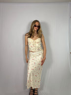Woman wearing a floral skirt set against a plain background