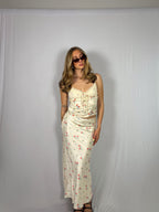 Woman wearing a floral skirt set against a plain white background