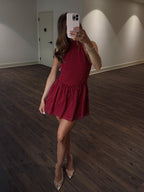 Person wearing a red polka dot dress in an indoor setting