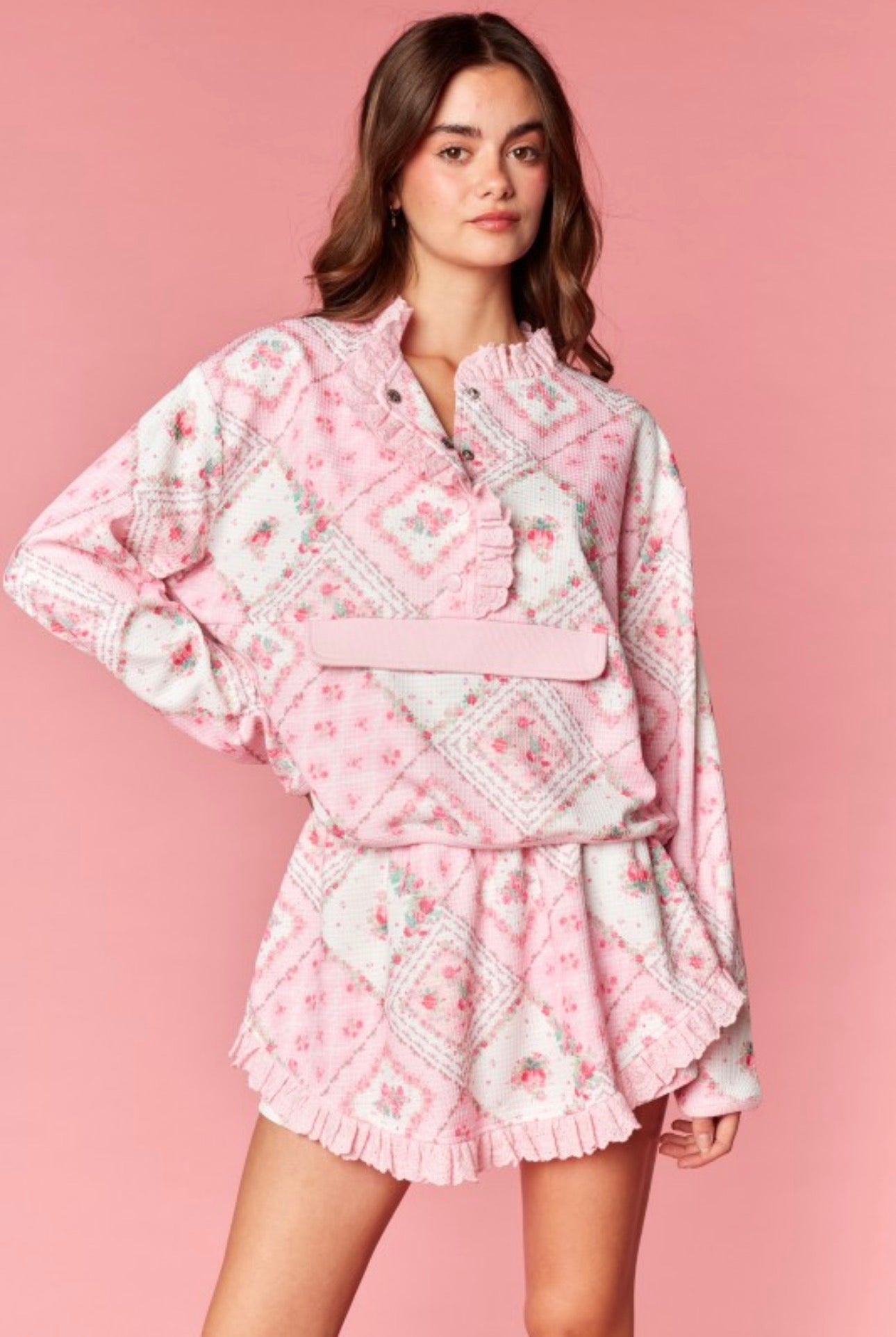 Woman wearing a pink floral outfit on a pink background