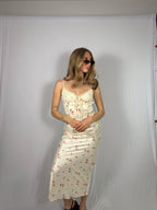 Woman wearing a floral skirt set against a plain background