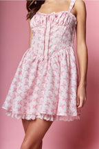 Pink floral dress on a model against a pink background