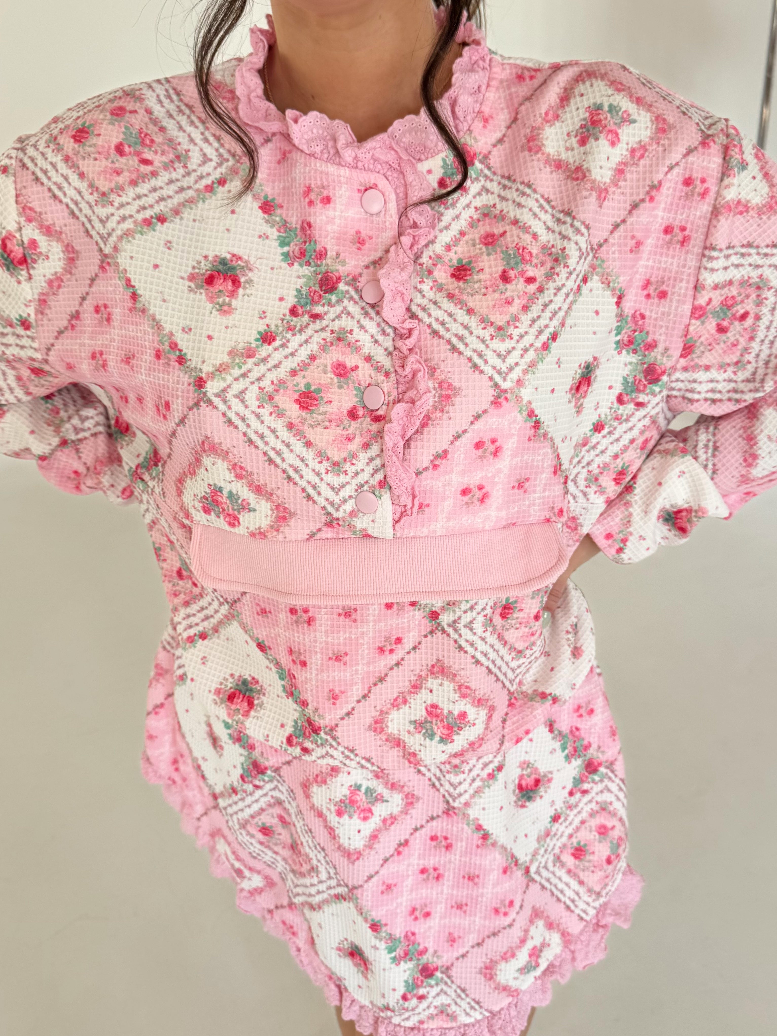 Pink patchwork outfit with floral patterns on a neutral background